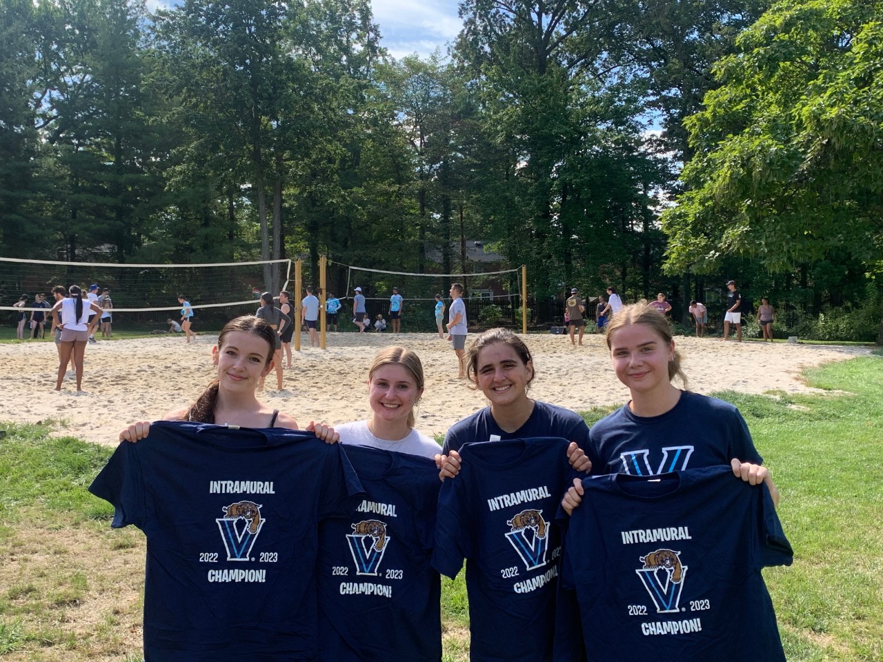 Female students posing for sand volleyball champion photo