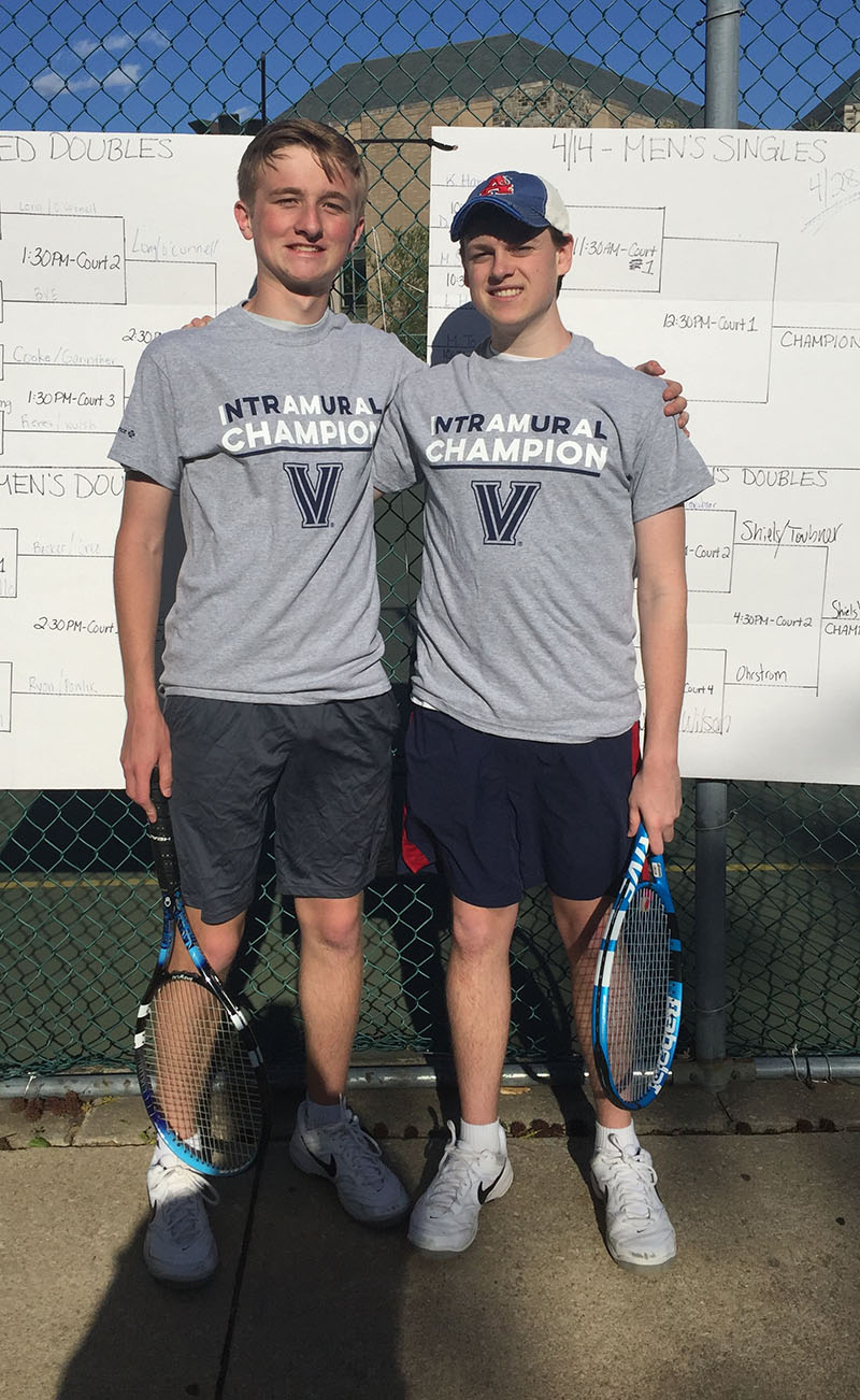 Two male students posing for doubles tennis champion photo