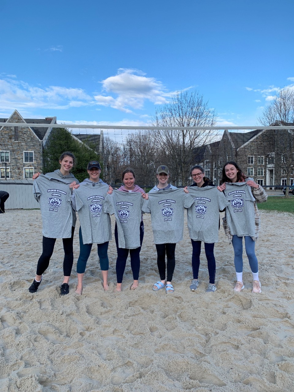 Female students posing for sand volleyball champion photo
