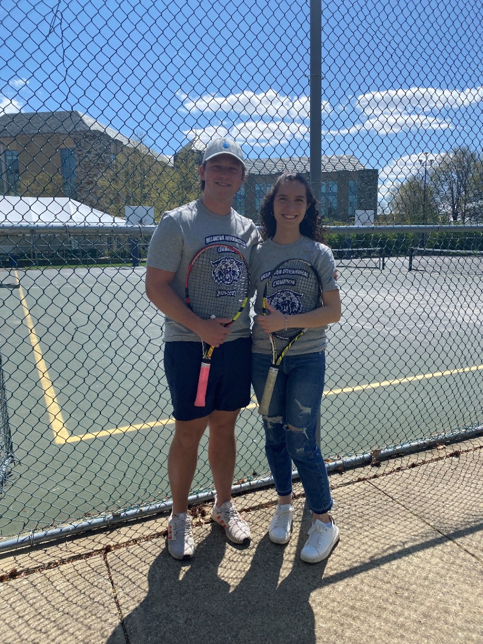 Two students posing for doubles tennis champion photo
