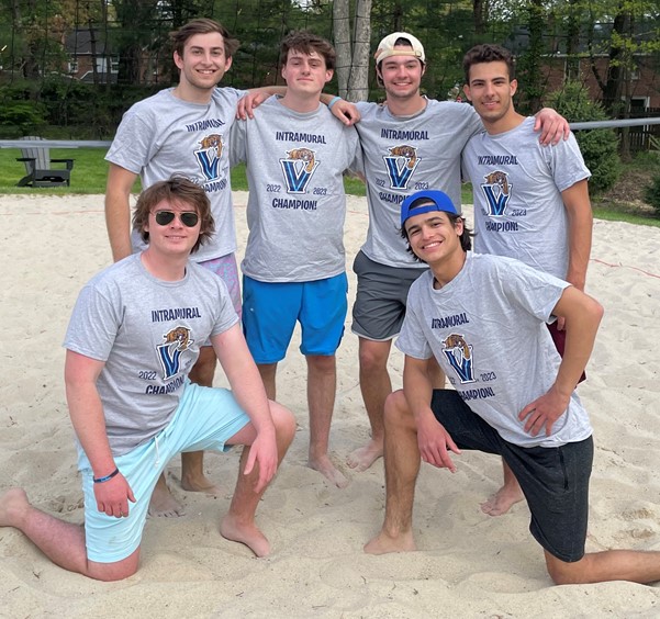 Male students posing for sand volleyball champion photo