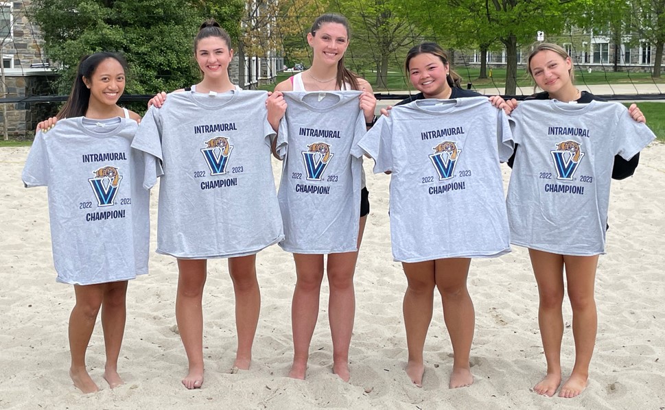 Female students posing for sand volleyball champs photo